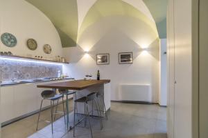 a kitchen with a bar with stools and a ceiling at Elle Suite in Lecce