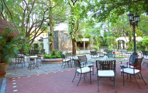 een patio met tafels, stoelen en bomen bij Hotel Valles in Ciudad Valles