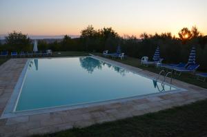 een zwembad met een zonsondergang op de achtergrond bij AGRITURISMO SANTA BARBARA COUNTRY HOUSE in San Miniato