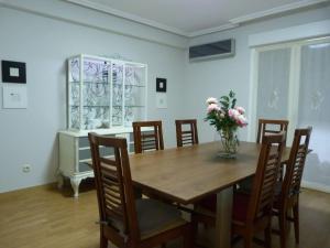 a dining room with a table and chairs with a vase of flowers at Luengo House in León