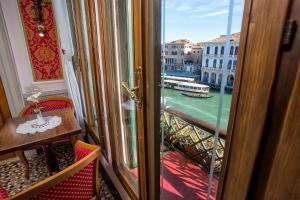 uma porta para uma varanda com vista para um rio em Antica Locanda Sturion Residenza d'Epoca em Veneza