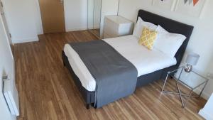 een slaapkamer met een groot bed met een zwart hoofdeinde bij Quay Apartments in Manchester