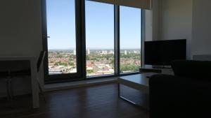 een woonkamer met grote ramen en een flatscreen-tv bij Quay Apartments in Manchester