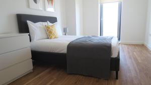 een slaapkamer met een bed met een zwart hoofdeinde en een raam bij Quay Apartments in Manchester