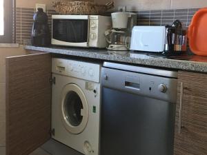 cocina con lavadora y microondas en Ria Apartments, en Olhão