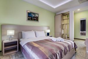 una camera da letto con un grande letto con due asciugamani di Riva Residence a Herceg-Novi