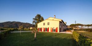 a white house with a palm tree in the yard at Cascina Canova B&B in San Giuliano Terme