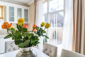 eine Vase von Blumen, die auf einem Tisch vor einem Fenster sitzt in der Unterkunft KApartments in Warna