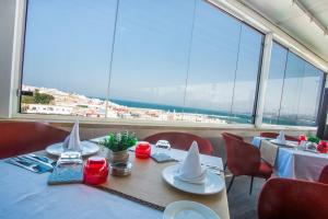 comedor con mesa y sillas y ventana grande en Fredj Hotel, en Tánger