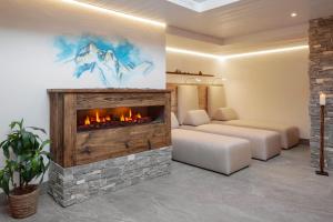 a living room with a fireplace and a couch at Hotel Antika in Zermatt