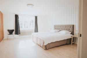 Un dormitorio blanco con una cama grande y una ventana en The Light House, en Borre