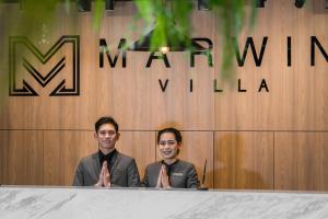 two men in suits sitting at a table with their ties at Marwin Villa in Bangkok