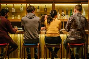 un gruppo di persone seduti al bar di Irori Guest House Tenmaku a Hakone