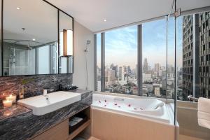 a bathroom with a tub and a large window at Sivatel Bangkok Hotel in Bangkok