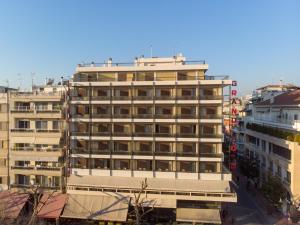 a tall building with many windows in a city at Grand Hotel in Larisa