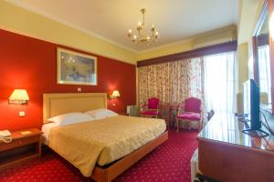 a hotel room with a bed and a television at Grand Hotel in Larisa