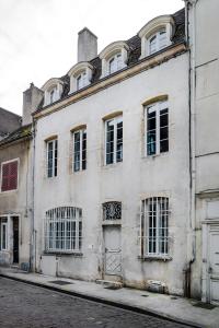 een oud wit gebouw aan de straatkant bij La Maison Blanche in Beaune