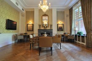 uma sala de jantar com uma mesa e cadeiras e um lustre em Landgoed Huize Bergen Den Bosch - Vught em Den Bosch