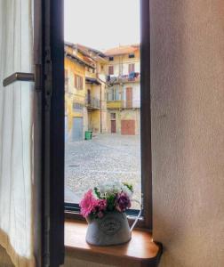 um vaso com flores sentado no peitoril da janela em PICCOLA VILLA nel Centro Storico em Arona