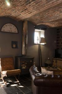 a living room with a couch and a clock on the wall at Gîte de Corbion Loft1 in Ciney