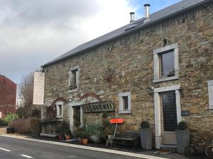 a stone building with a bench in front of it at Gîte de Corbion Loft1 in Ciney