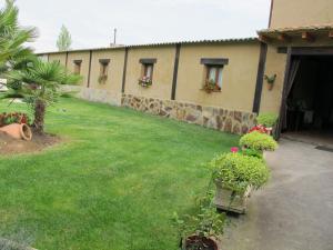 un edificio con un cortile fiorito e piante di Albergue San Pelayo a Villarente