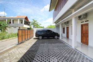 une voiture garée dans l'allée d'une maison dans l'établissement Griya Izzara Guest House Syariah, à Sleman