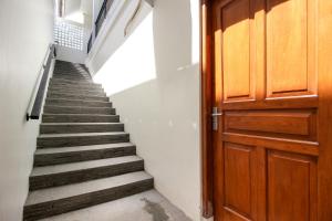 Un escalier mène à une porte en bois. dans l'établissement Griya Izzara Guest House Syariah, à Sleman