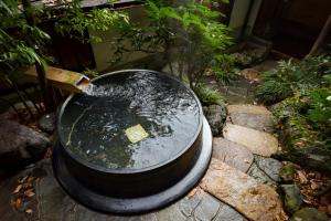 a bucket of water sitting on top of rocks at Kyo no Minshuku Ohara no Sato in Kyoto