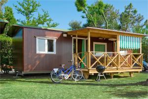 una bicicleta estacionada frente a una casa pequeña en Camping Village Capalonga, en Bibione