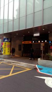 Un bâtiment avec des gens qui marchent devant lui dans l'établissement Persimmon Hotel, à Hsinchu