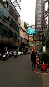 Une femme marchant dans une rue d'une ville dans l'établissement Persimmon Hotel, à Hsinchu