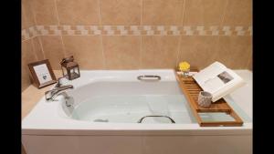 a bathroom with a bath tub with a book on it at The Cottage in Aberdeen