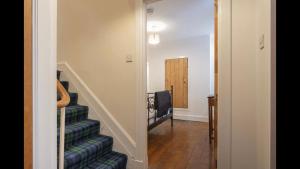 a hallway with a stairway with a blue carpet at The Cottage in Aberdeen