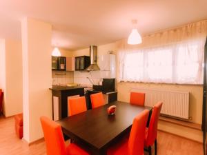 a dining room with a table and orange chairs at Spacious Apartment near Peles in Sinaia