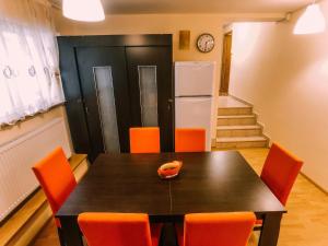 a dining room with a table and orange chairs at Spacious Apartment near Peles in Sinaia