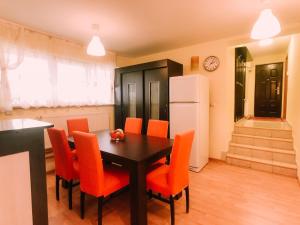 a dining room with a table and orange chairs at Spacious Apartment near Peles in Sinaia