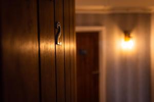 una porta in legno con luce accanto a un corridoio di REM Hotel a Manchester