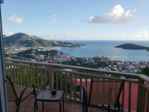 balcón con mesa, sillas y vistas al océano en Little Indigo Apartments, en Mafolie