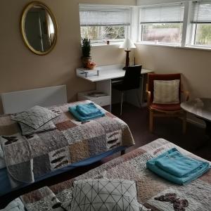 - une chambre avec 2 lits, un bureau et un miroir dans l'établissement Risskov Bellevue Guesthouse, à Aarhus