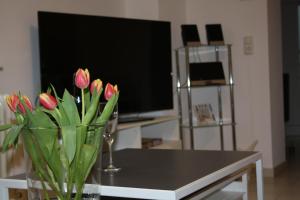 a vase of flowers on a table in front of a tv at Schöne 60qm große Wohnung Mainz-Lerchenberg ZDF in Mainz