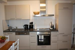 a kitchen with white cabinets and a stove top oven at Schöne 60qm große Wohnung Mainz-Lerchenberg ZDF in Mainz