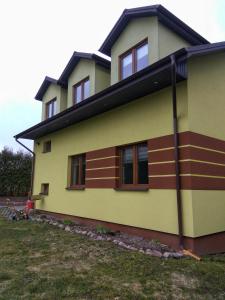 a yellow house with a black roof at Pokoje na Wiejskiej in Nałęczów