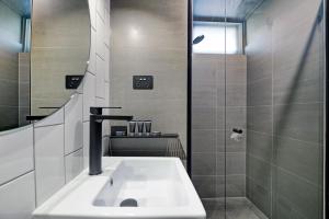 y baño con lavabo y ducha. en CBD Motor Inn, en Coffs Harbour