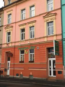 a pink building with a sign on the side of it at Penzion T&T in Cheb