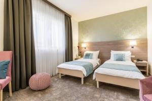 a hotel room with two beds and a chair at Hotel Mondo in Split