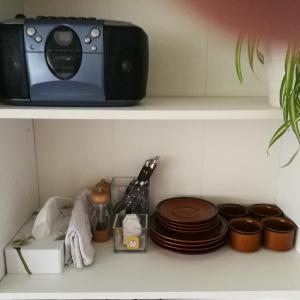 un four micro-ondes installé au-dessus d'une étagère avec des assiettes dans l'établissement Risskov Bellevue Guesthouse, à Aarhus