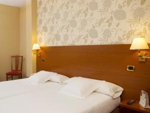 a bedroom with a large bed with a wooden headboard at Oca Ipanema Hotel in Vigo