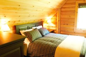 Una cama o camas en una habitación de Selenia Lodge- Résidences et Chalets dans les Laurentides