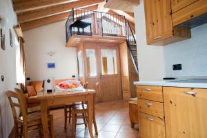 une cuisine avec une table en bois et un escalier en colimaçon dans l'établissement Chalet la Coccinella, à Livigno